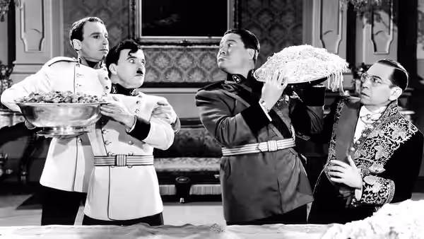 Adenoid Hynkel (Charlie Chaplin) with three men in formal uniforms and attire