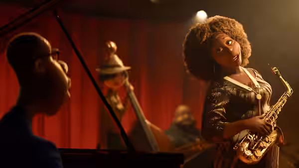 Dorothea (Angela Bassett) holding a saxophone before red curtains with band