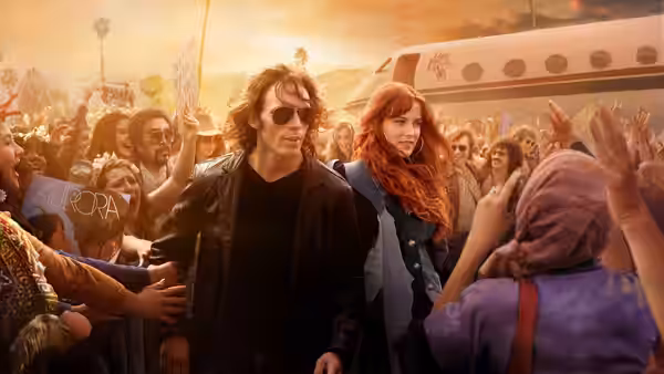 Billy Dunne (Sam Claflin) and Daisy Jones (Riley Keough) walk through a cheering crowd