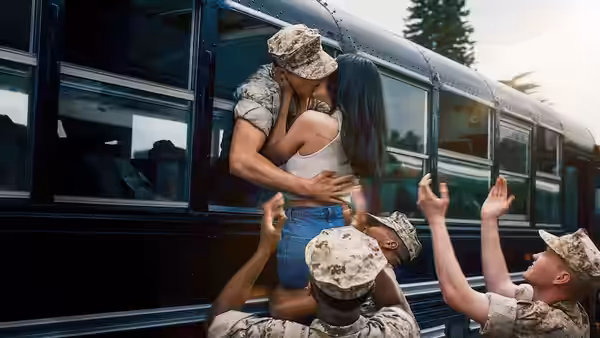 Luke Marrow kisses Cassie Salazar on a bus as soldiers in camouflage reach up to them