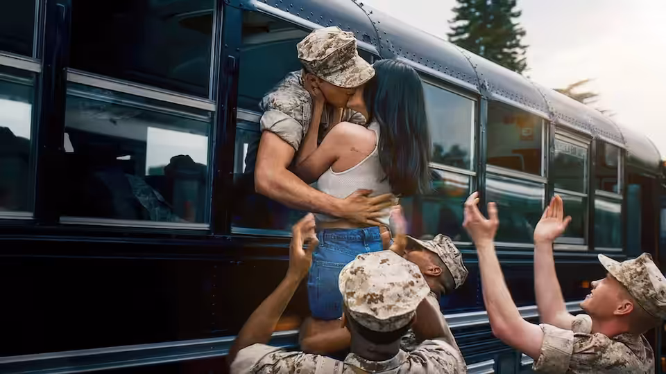 Luke Marrow kisses Cassie Salazar on a bus as soldiers in camouflage reach up to them