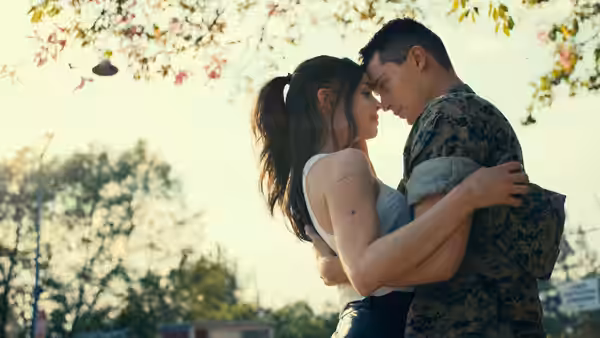 Cassie Salazar and Luke Marrow embrace with foreheads touching outdoors under autumn leaves