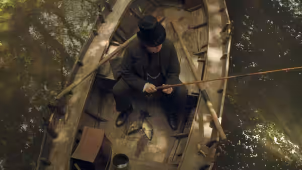 JMW Turner (Timothy Spall) sits fishing in a wooden boat