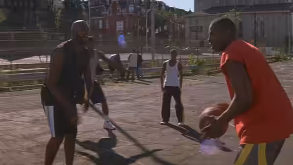young men play basketball on an outdoor urban court