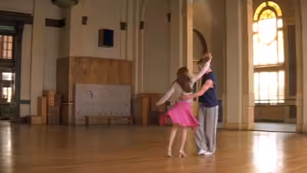 a couple dances together in a spacious empty studio