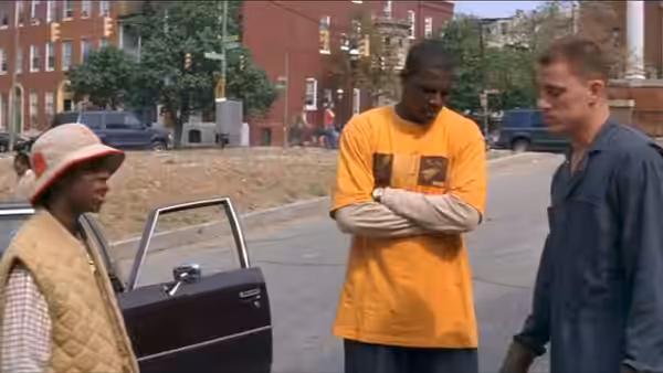 three people stand beside an open car on a city street