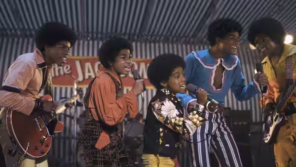 The Jackson 5 singing and playing instruments on a decorated stage