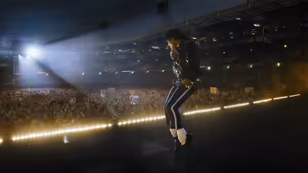 Michael (Jaafar Jackson) dancing on stage before a packed stadium crowd