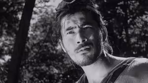 Tajômaru (Toshirō Mifune) with sweaty face looking upward in the woods