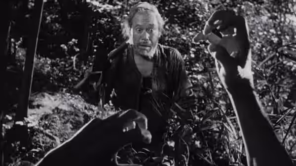 Woodcutter (Takashi Shimura) looking surprised among trees with hands in view