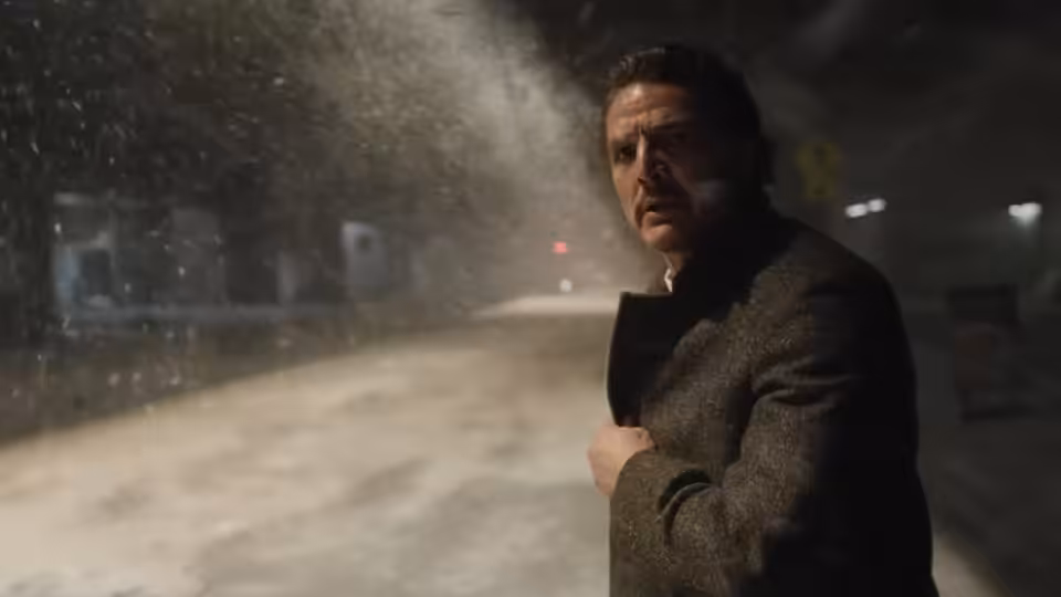 Alex Serian (Pedro Pascal) standing in a snowy street during a blizzard