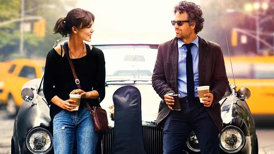 Dan (Mark Ruffalo) and Gretta (Keira Knightley) holding coffee beside a vintage car