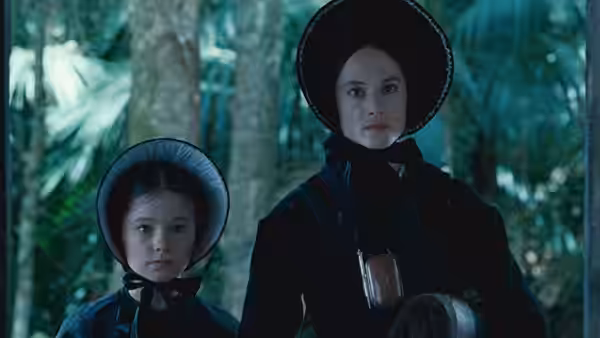 Ada McGrath (Holly Hunter) and Flora (Anna Paquin) standing among trees in a forest