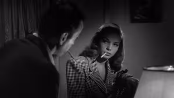 Harry Morgan (Humphrey Bogart) faces Marie Browning (Lauren Bacall) across a table