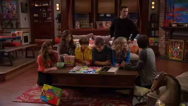 Group of children play a board game around a living room table