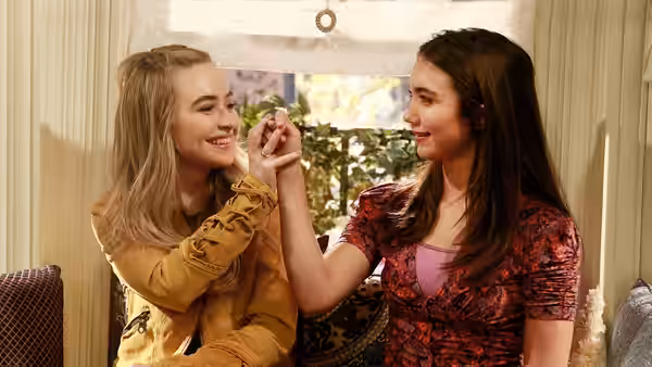 Maya Hart (Sabrina Carpenter) and Riley Matthews (Rowan Blanchard) hold hands smiling