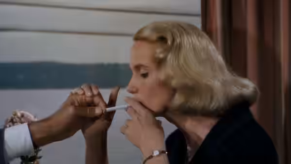 Eve Kendall (Eva Marie Saint) having a cigarette lit by a man