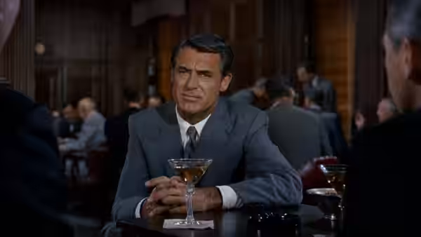 Roger Thornhill (Cary Grant) seated at a bar holding a martini glass