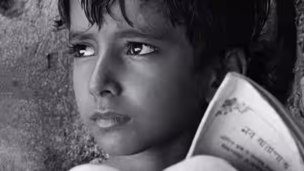 Young boy holds open book and looks upward with worried expression
