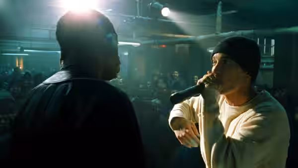 Jimmy (Eminem) rapping into a microphone on stage at a club