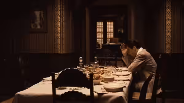 Michael Corleone (Al Pacino) resting his head in his hands at an empty table