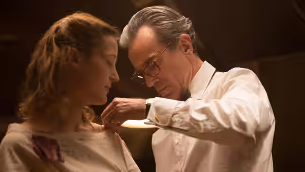 Reynolds Woodcock (Daniel Day-Lewis) fitting a dress on Alma Elson (Vicky Krieps)
