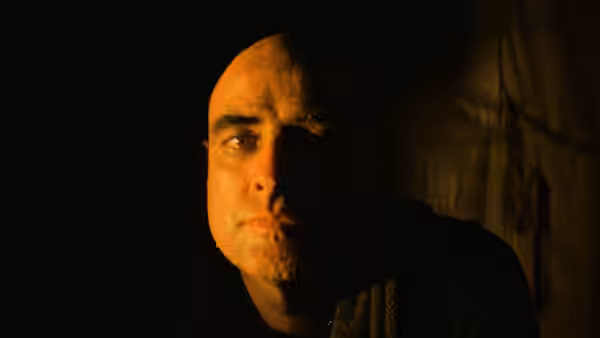 Colonel Walter Kurtz (Marlon Brando) stares forward in dim light