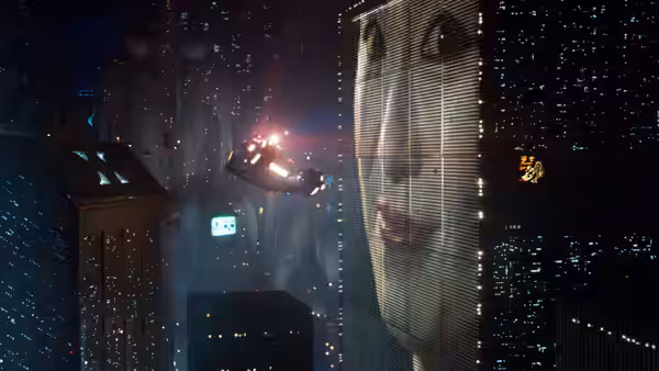 flying vehicle passing a massive illuminated face on the side of a building