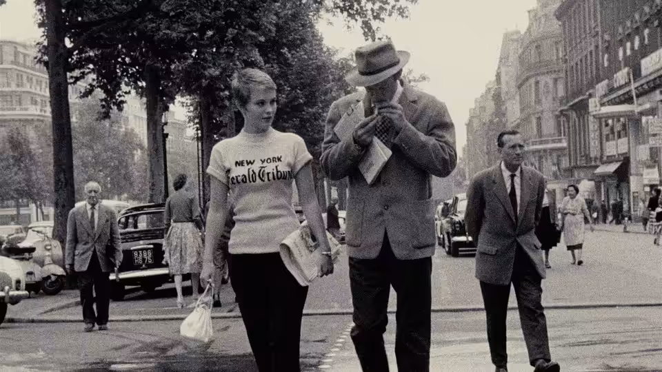 Patricia (Jean Seberg) and Michel (Jean-Paul Belmondo) walk along a busy Paris street