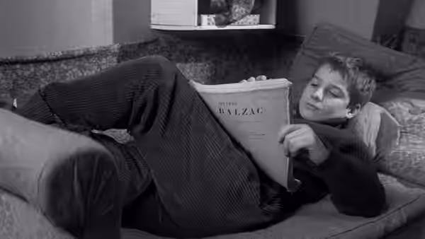 Antoine Doinel (Jean-Pierre Léaud) reclining on a sofa while reading a book