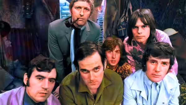 Five men in colorful suits stare directly toward the camera