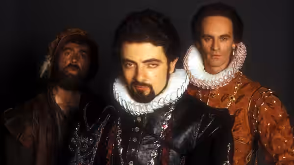 Edmund Blackadder (Rowan Atkinson) standing between two men in Elizabethan costume