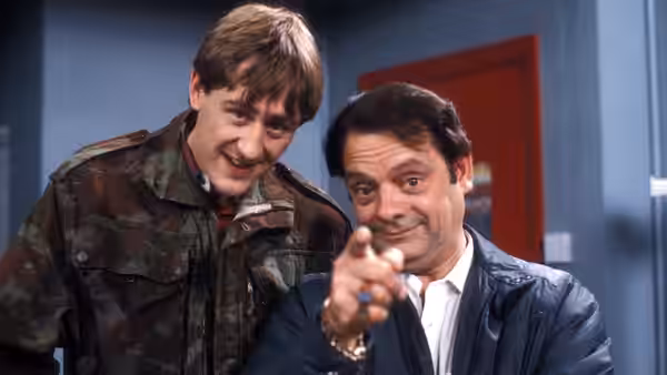 Rodney (Nicholas Lyndhurst) and Del Boy (David Jason) make faces indoors with Del Boy pointing