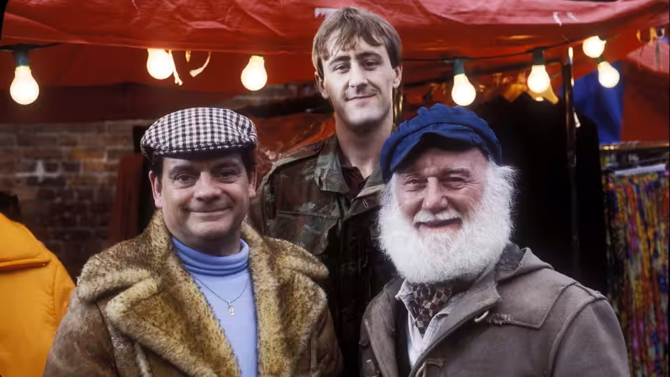 Del Boy (David Jason) Rodney (Nicholas Lyndhurst) and Uncle Albert (Buster Merryfield) smile under a red canopy