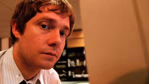 Tim Canterbury (Martin Freeman) seated and looking sideways in an office
