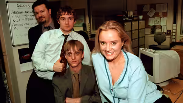 David Brent (Ricky Gervais) and three colleagues posing together in an office
