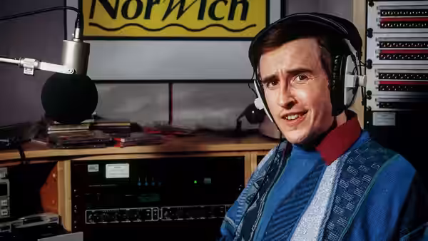 Alan Partridge (Steve Coogan) wears headphones in a radio studio