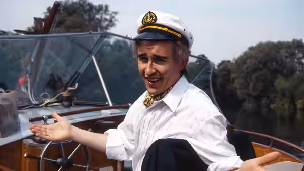 Alan Partridge (Steve Coogan) gestures while seated on a boat