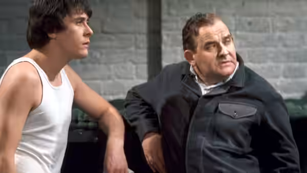 Godber (Richard Beckinsale) and Fletcher (Ronnie Barker) seated together looking to one side