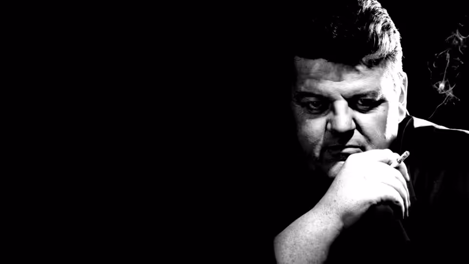 Fitz (Robbie Coltrane) smoking a cigarette in the dark