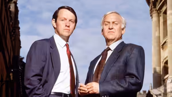 Chief Inspector Morse (John Thaw) and Detective Sergeant Lewis (Kevin Whately) stand outdoors