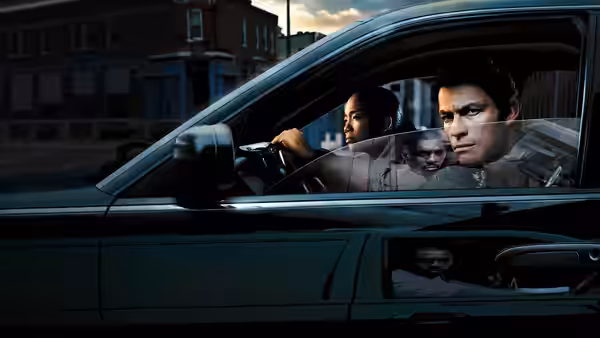 Kima Greggs (Sonja Sohn) driving a car with Jimmy McNulty (Dominic West) in the passenger seat