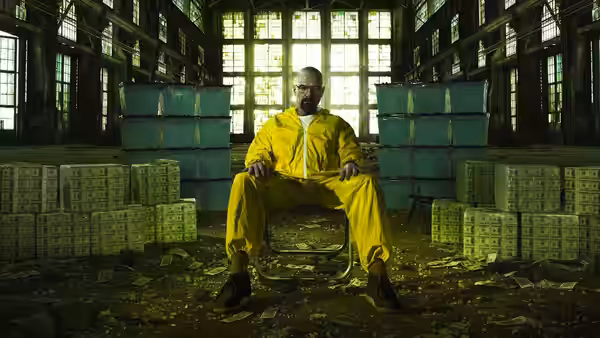 Walter White (Bryan Cranston) seated among stacks of cash in an abandoned warehouse