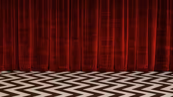 Red velvet curtains above a black and white chevron patterned floor