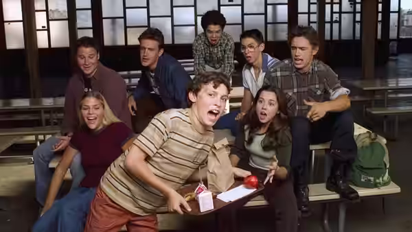 Students reacting with surprise around a cafeteria lunch table