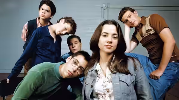 Group of students posing casually against a plain wall