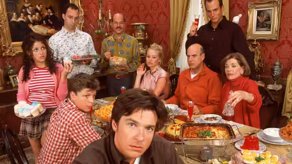 Michael Bluth (Jason Bateman) sits at a dinner table with his family gathered around