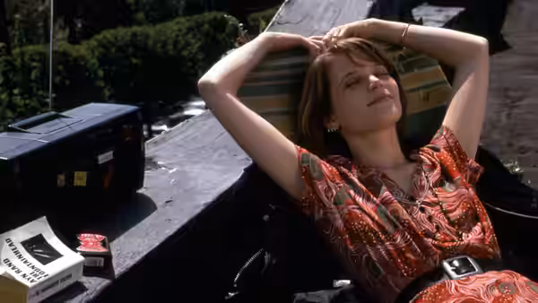 Janet Livermore (Bridget Fonda) reclining outdoors with arms raised behind her head