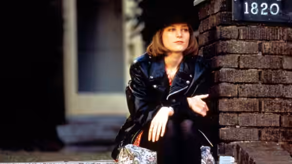Janet Livermore (Bridget Fonda) in black hat and leather jacket on steps
