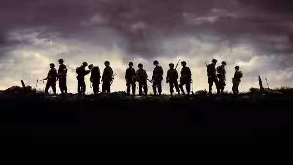 Group of soldiers standing in silhouette on a hilltop at dusk